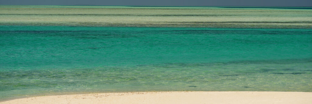 Photographie « Horizon1 », série Horizons de Sabine Chabot. Le sable blanc et les nuances turquoise de l’océan composent un paysage en strates horizontales.