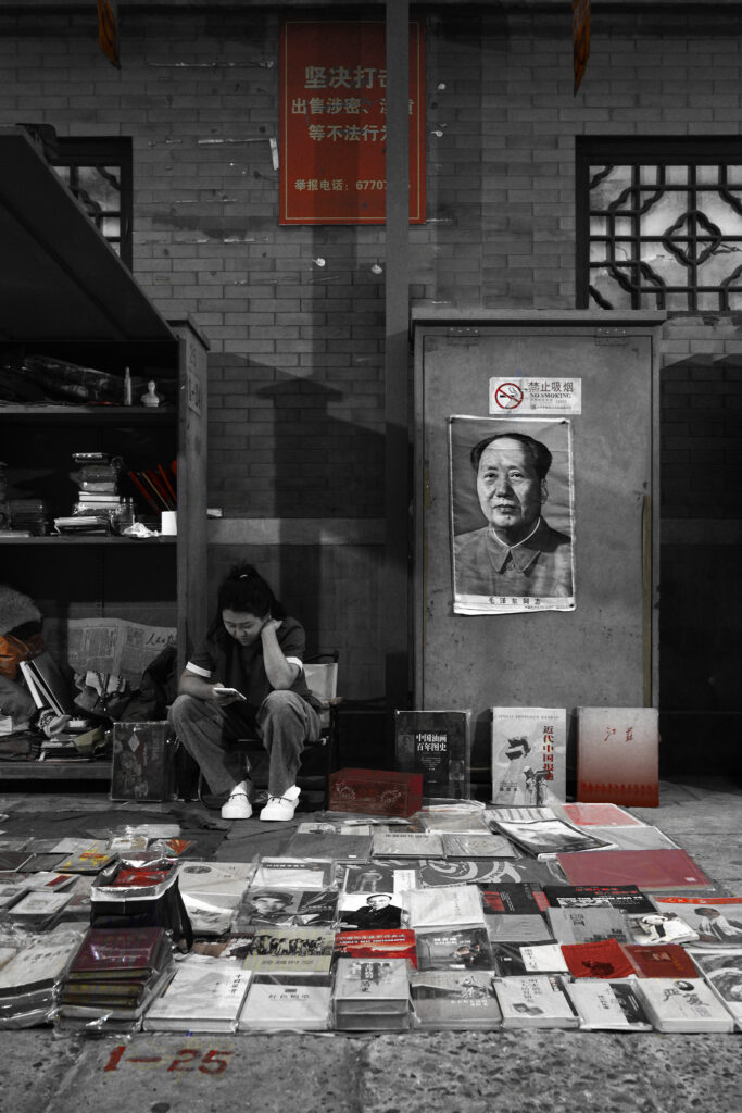 Photographie « Mao », série Rouge Chine de Sabine Chabot : Mao veille sur la librairie, tandis que le présent s’échappe dans un écran.