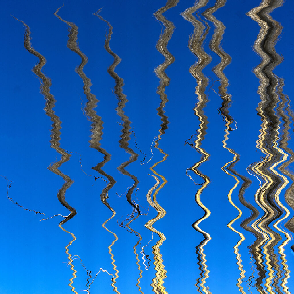 Photographie « Bleu », série Photo Raku® de Sabine Chabot : Roseaux sur le ciel bleu interprétés façon photo Raku®.
