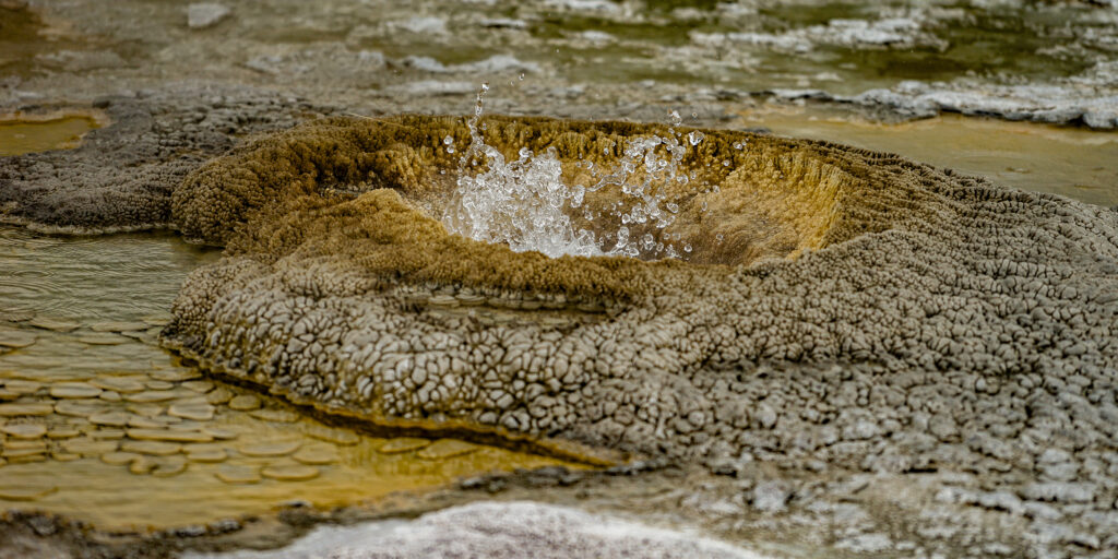 Photographie « Le grand Prismatic 5 », série Prismatic de Sabine Chabot : Au ras du sol, les émanations de soufre donnent un aspect lunaire au paysage.